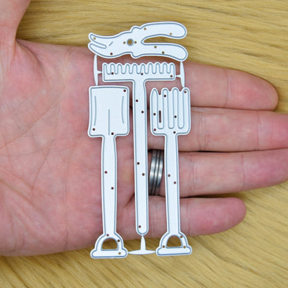 Spade, garden fork, rake and secateurs metal cutting dies held in a hand to show their overall size.