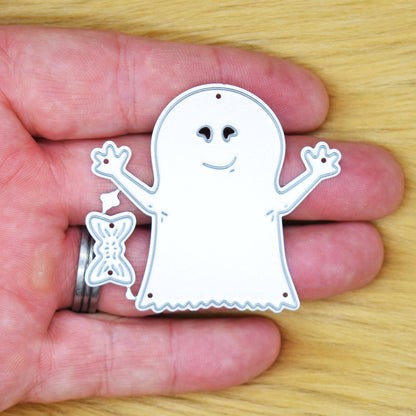 Friendly Halloween ghost and bow metal cutting dies held in hand to show their approximate size.