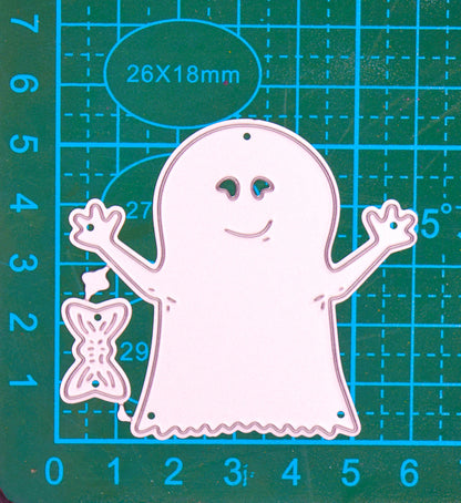 Friendly ghost and bow metal cutting die set shown on a centimetre cutting mat for size reference.