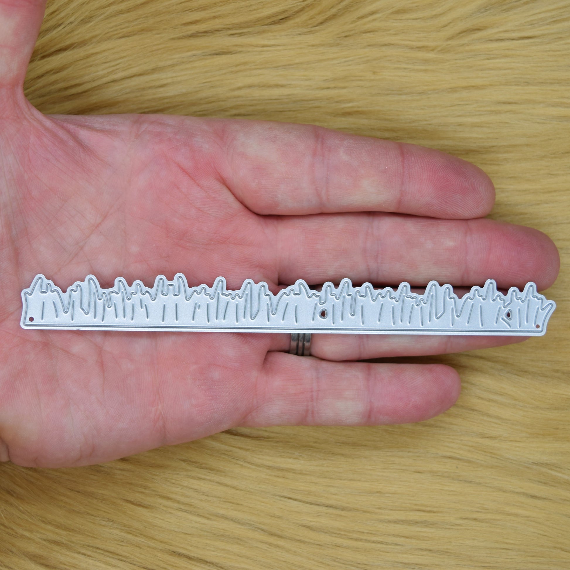 Grass border metal cutting die size reference shown in hand