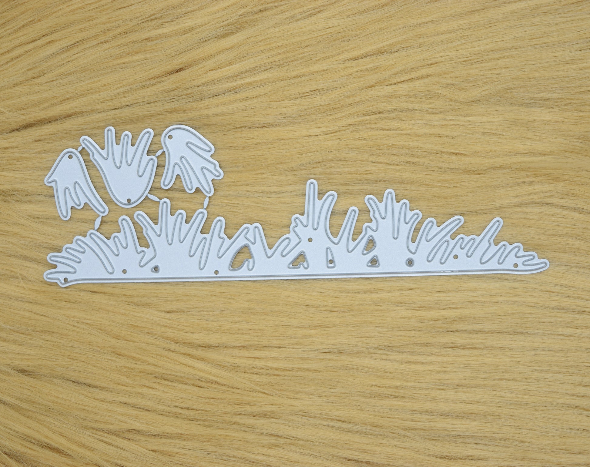 Grass border metal cutting dies set on wooden background