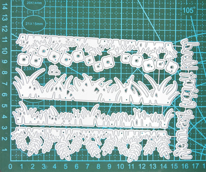 Grass and foliage border metal cutting dies on measured cutting mat showing die sizes