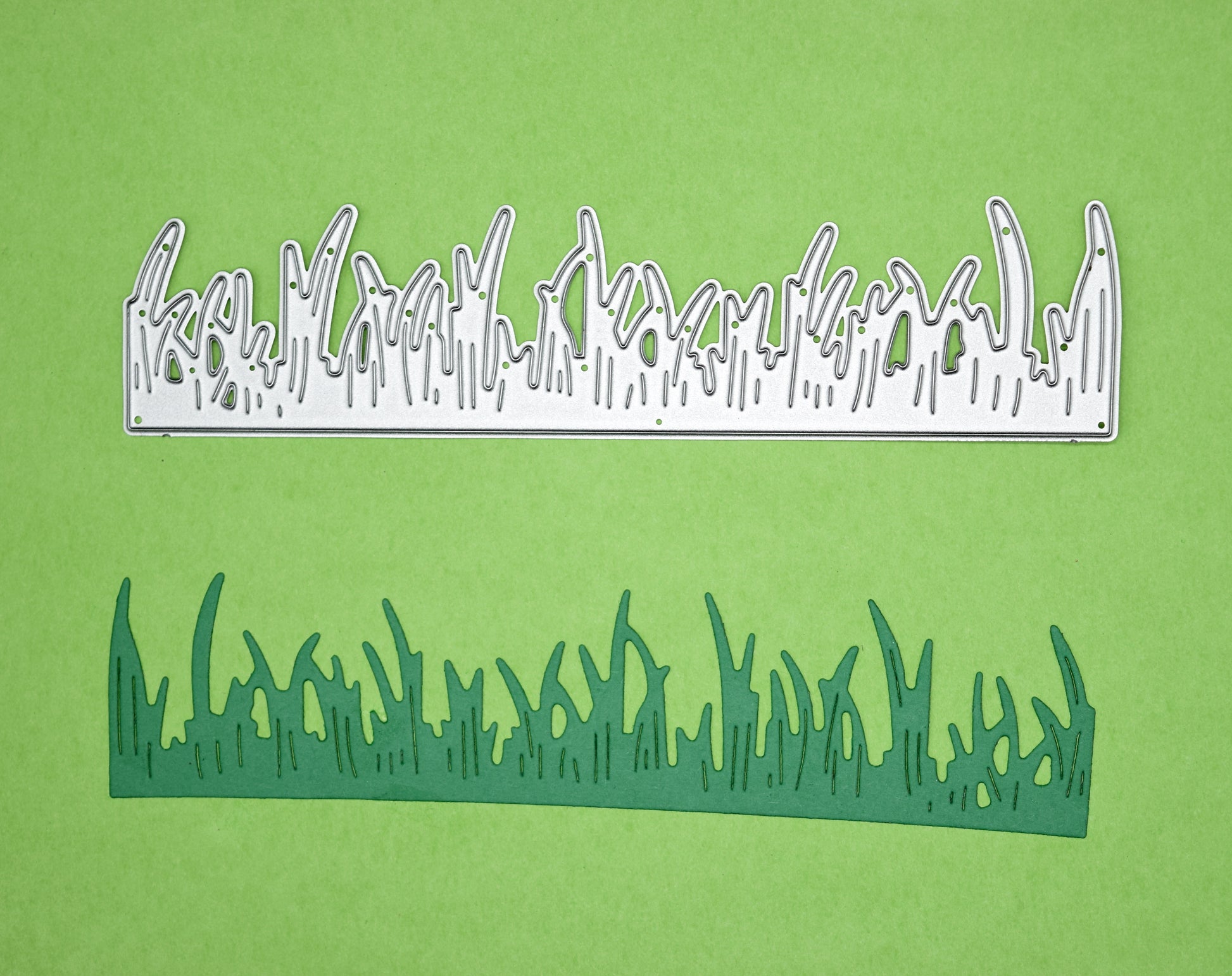Grass border metal cutting die with a finished green card cut shown on a green background