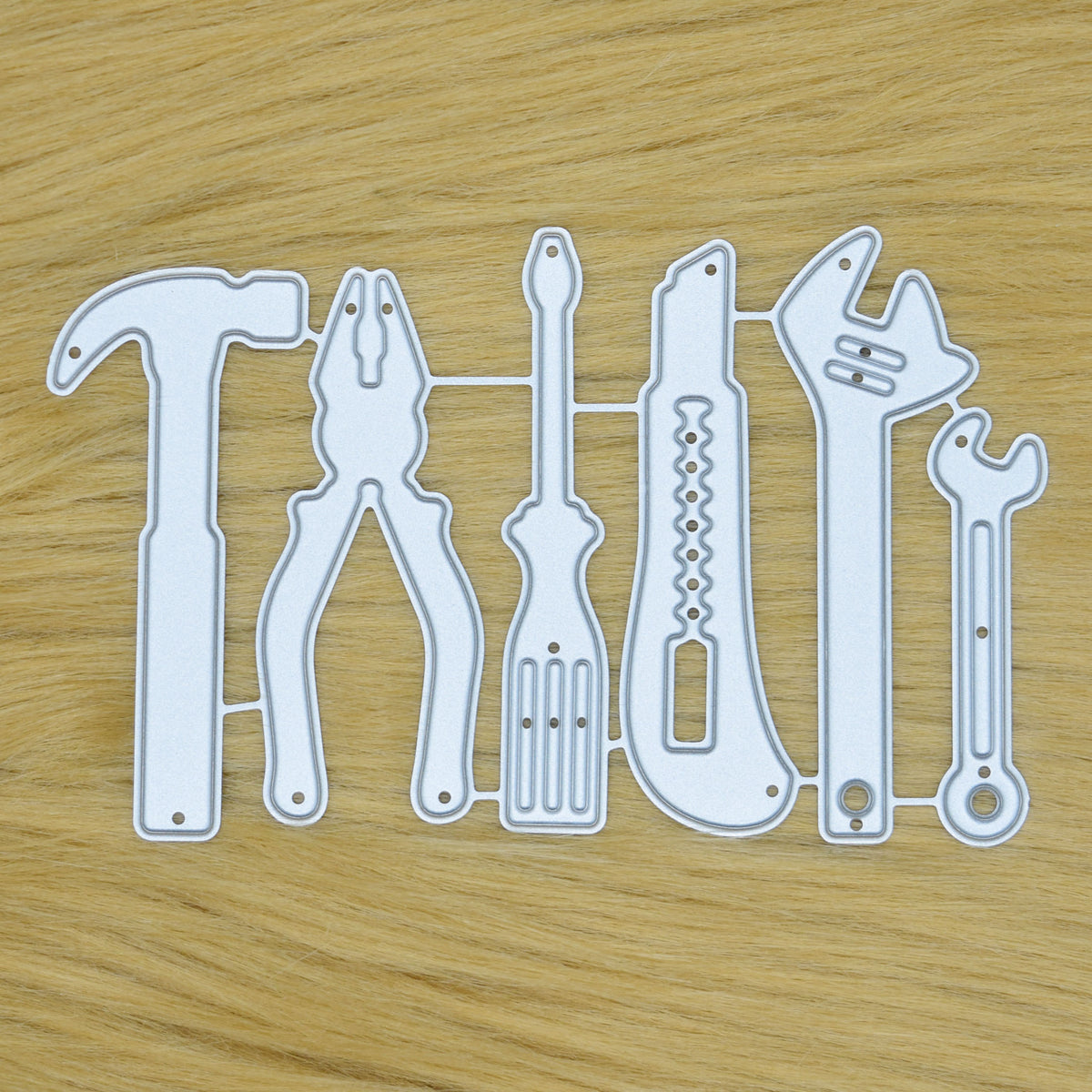 Hand tools metal cutting die set displayed on a faux fur background for card making and papercraft.