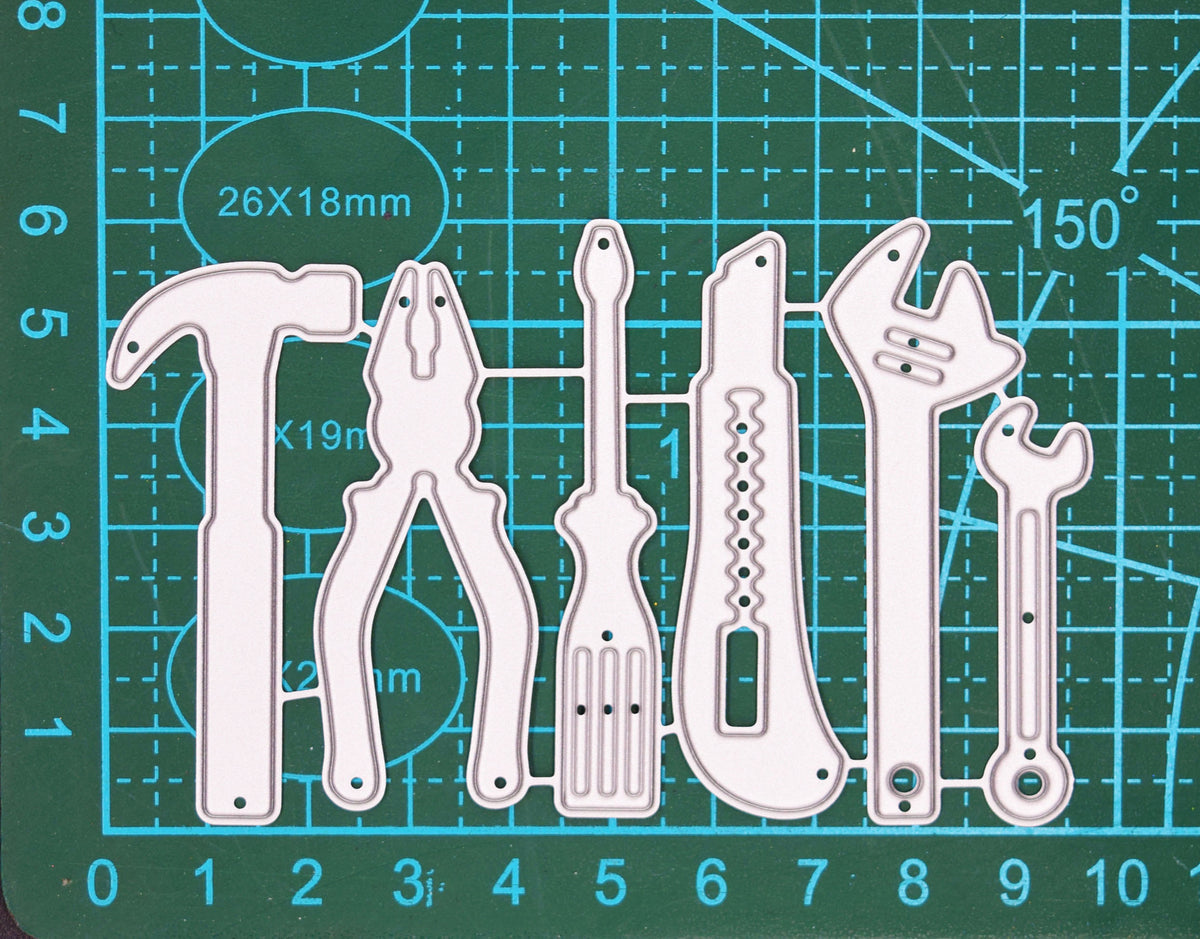 Hand tools metal cutting die set shown on a cutting mat for scale with six workshop tool designs.