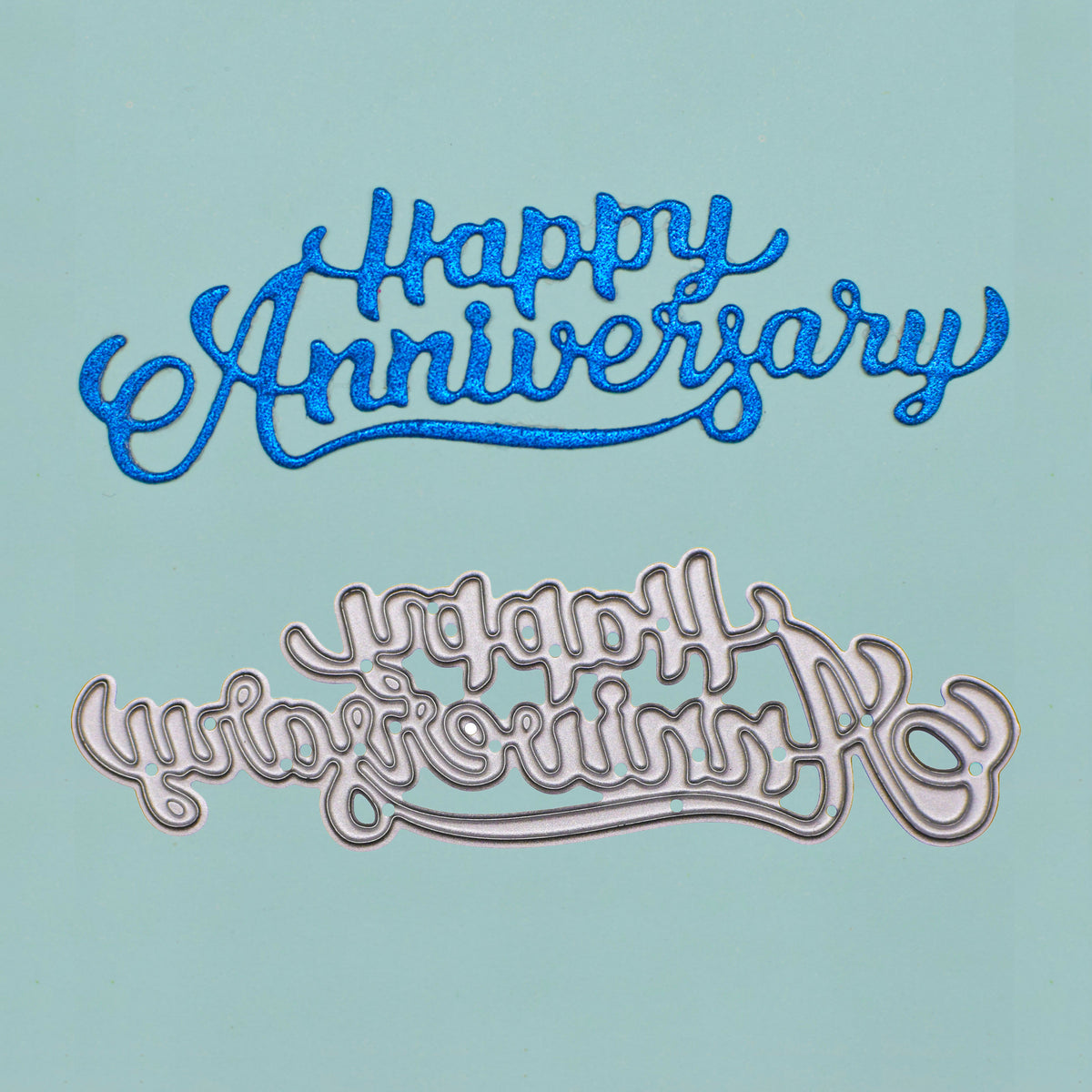 Blue glitter Happy Anniversary die cut displayed above the matching metal cutting die on pale blue card.