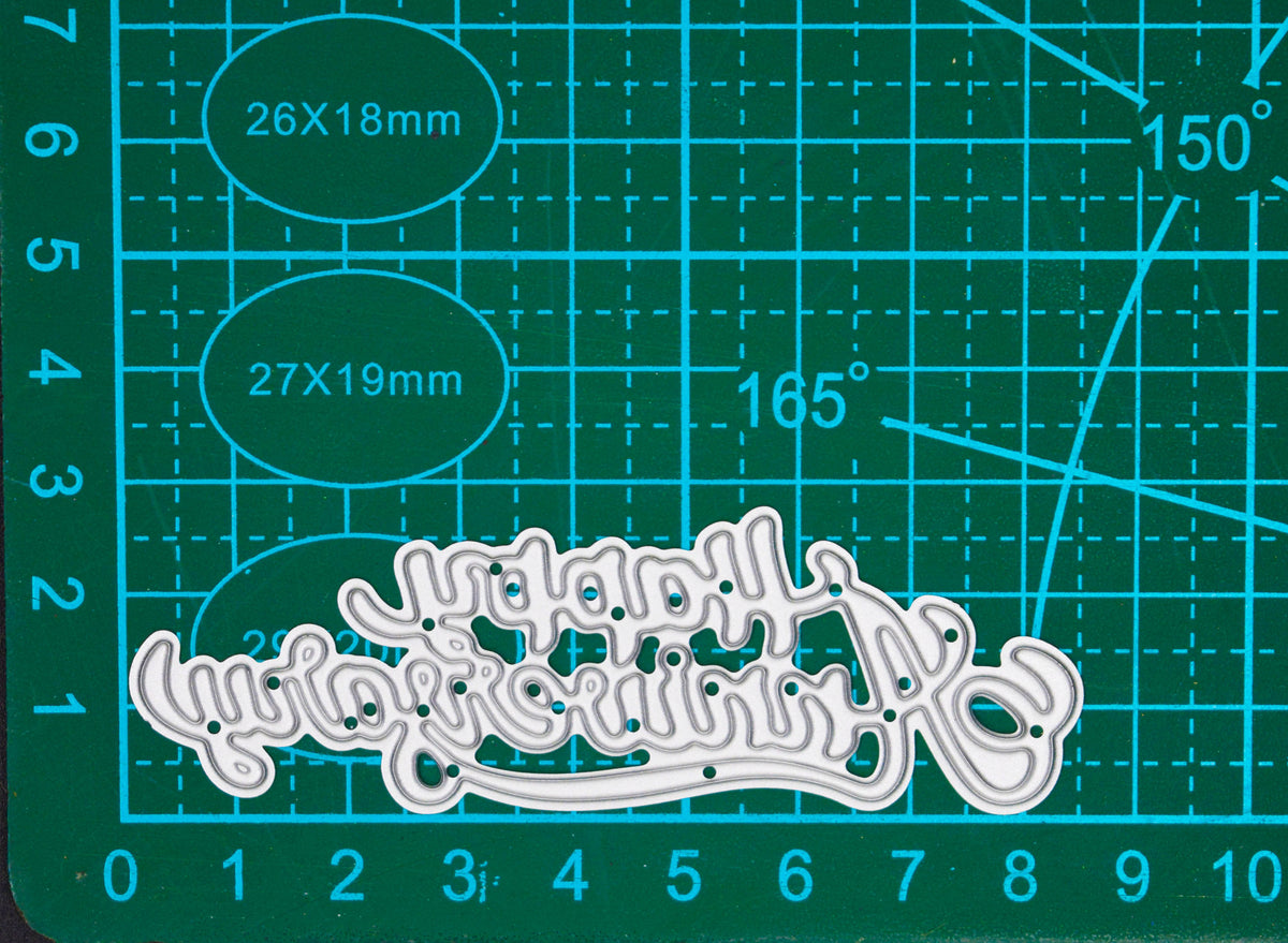 Happy Anniversary script metal cutting die displayed on a centimetre cutting mat for approximate size guidance.