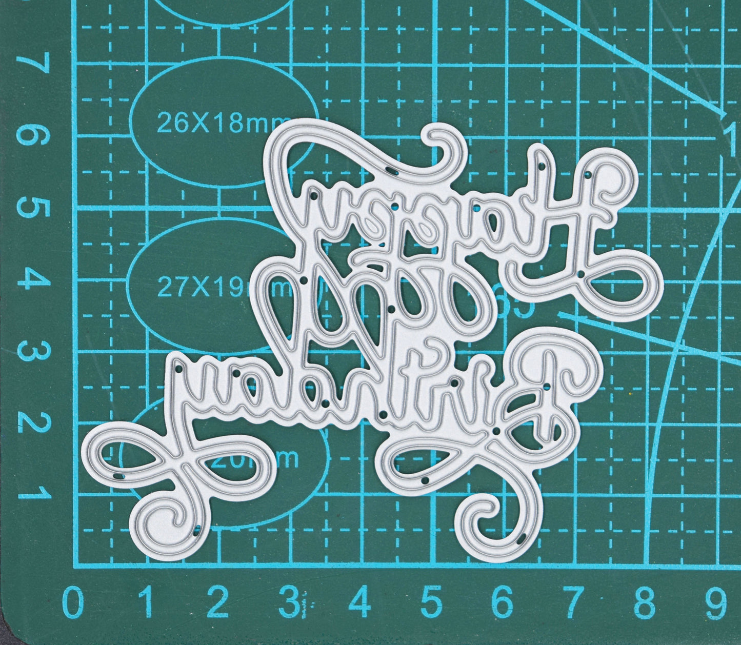 Happy Birthday calligraphy script metal cutting die on cutting mat showing elegant swirl sentiment design for card making and papercrafts