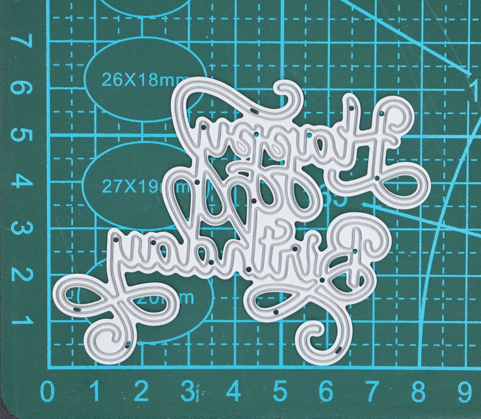 Happy Birthday calligraphy script metal cutting die on cutting mat showing elegant swirl sentiment design for card making and papercrafts