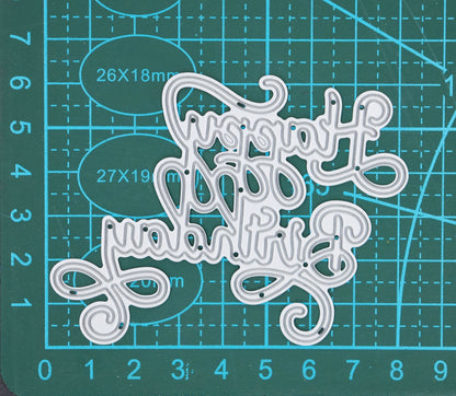 Happy Birthday calligraphy script metal cutting die on cutting mat showing elegant swirl sentiment design for card making and papercrafts