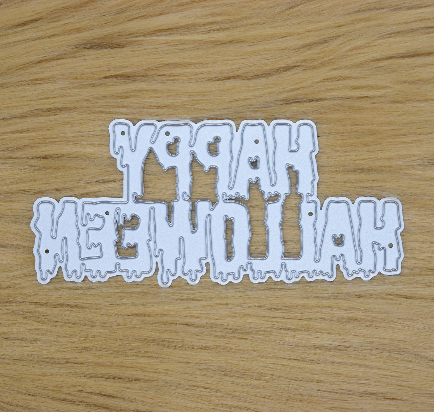 Happy Halloween drip text metal cutting die on faux fur background