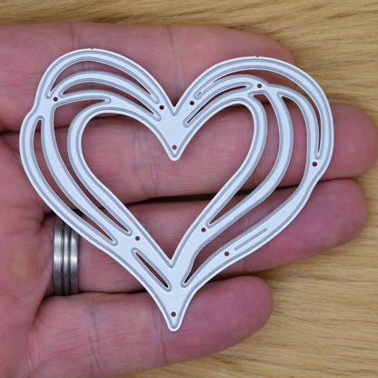 Heart metal cutting die on wood background