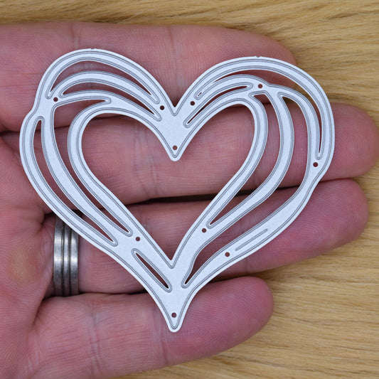 Heart metal cutting die on wood background