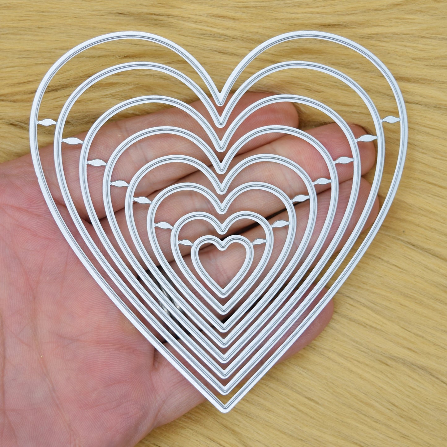 Heart nesting dies held in hand showing size range