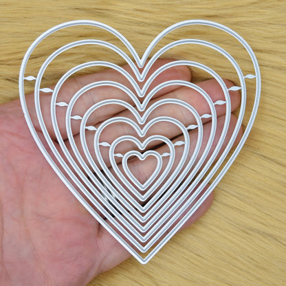 Heart nesting dies held in hand showing size range