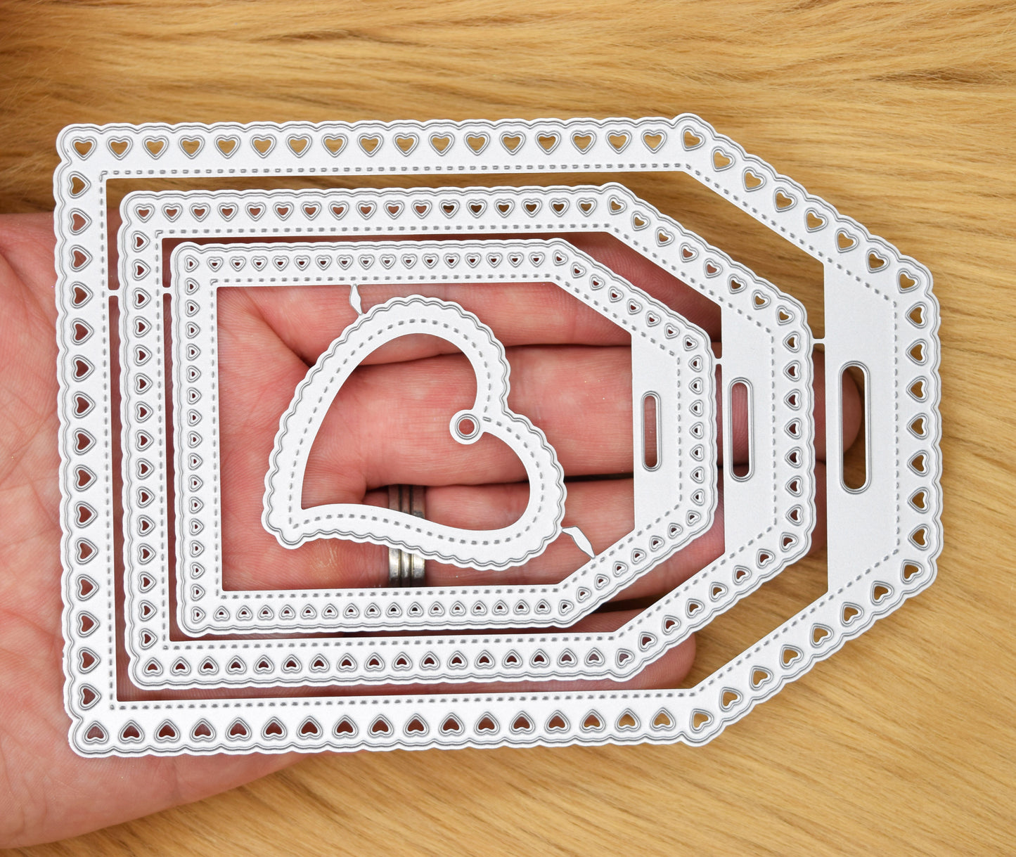 Heart tag nesting metal cutting dies held in hand showing size