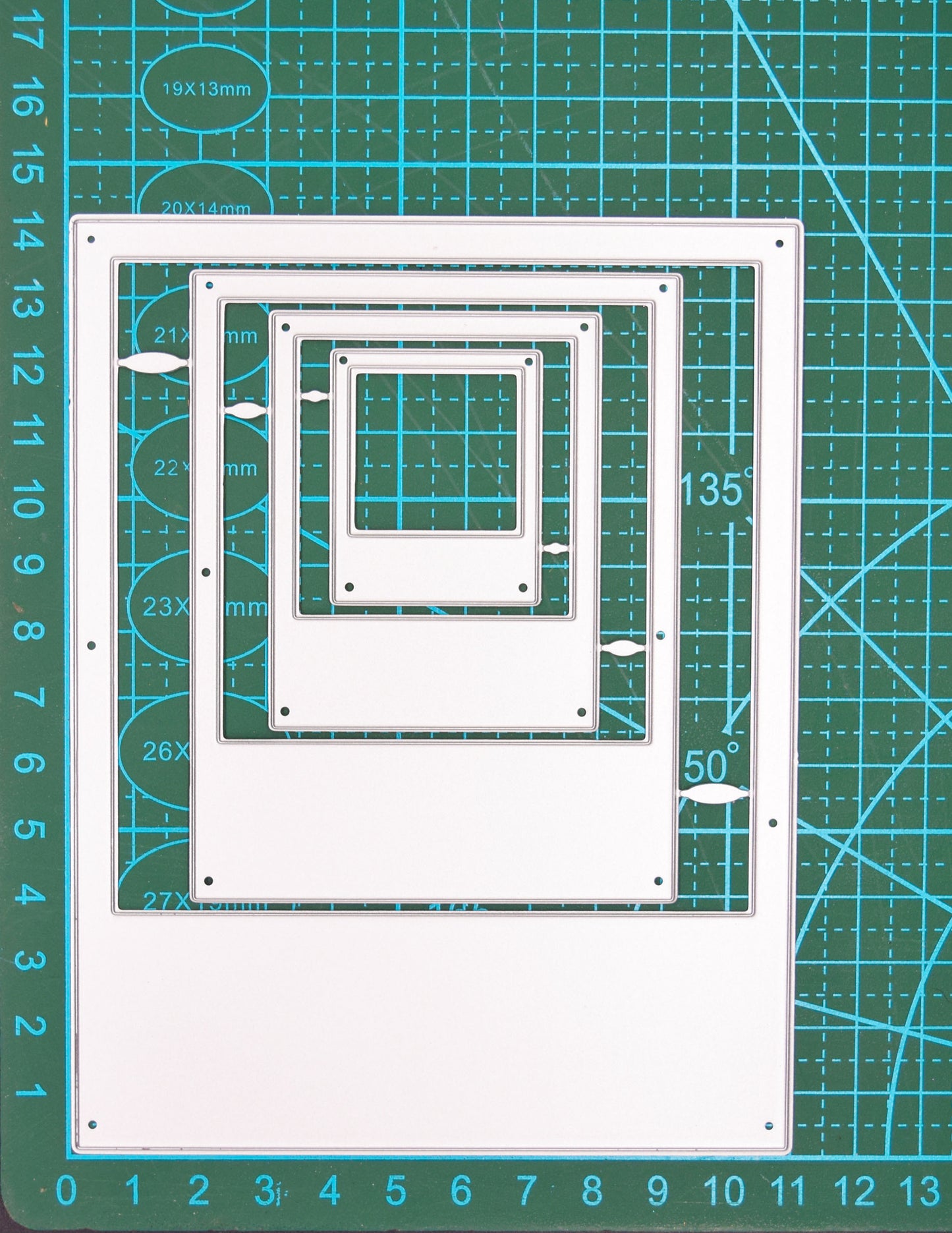 Instant camera frame nesting metal cutting dies shown on a centimetre cutting mat for size reference