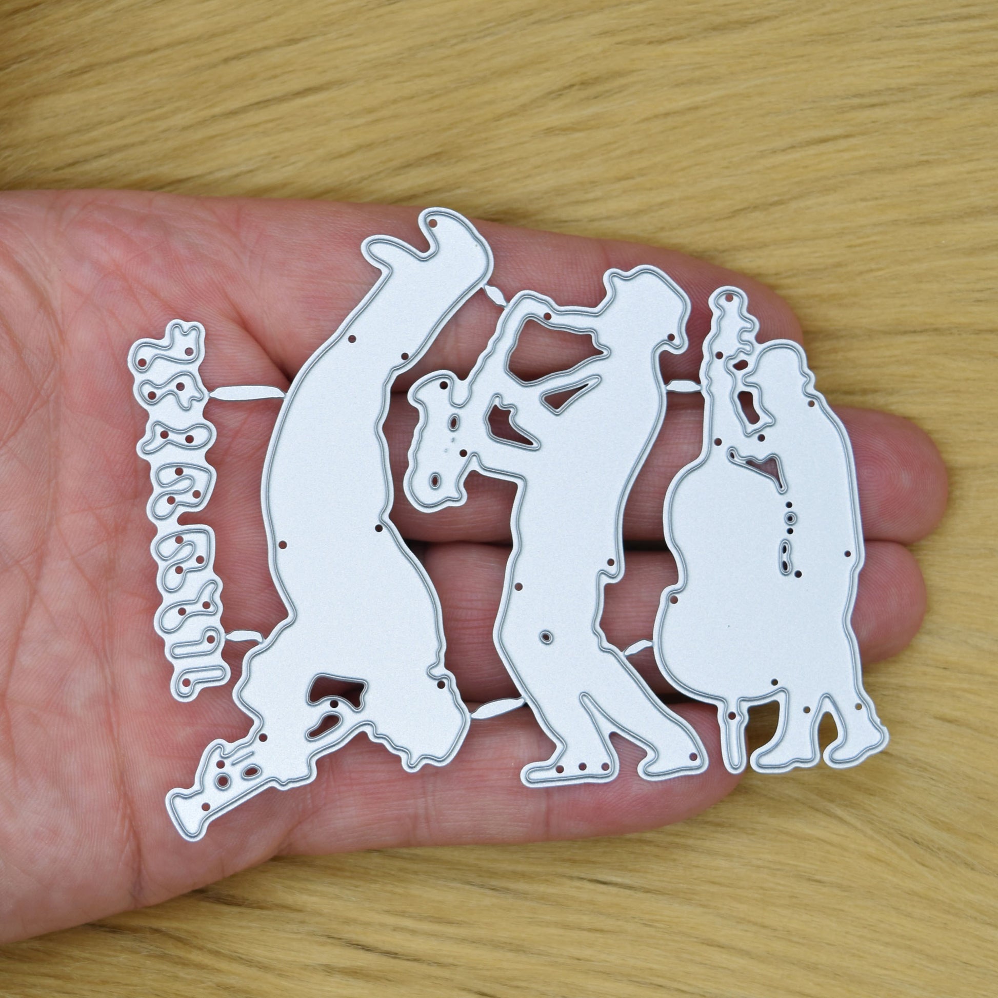 Jazz swing band and music notes metal cutting dies set shown in hand on a faux fur background to demonstrate the size for card making and papercrafts.