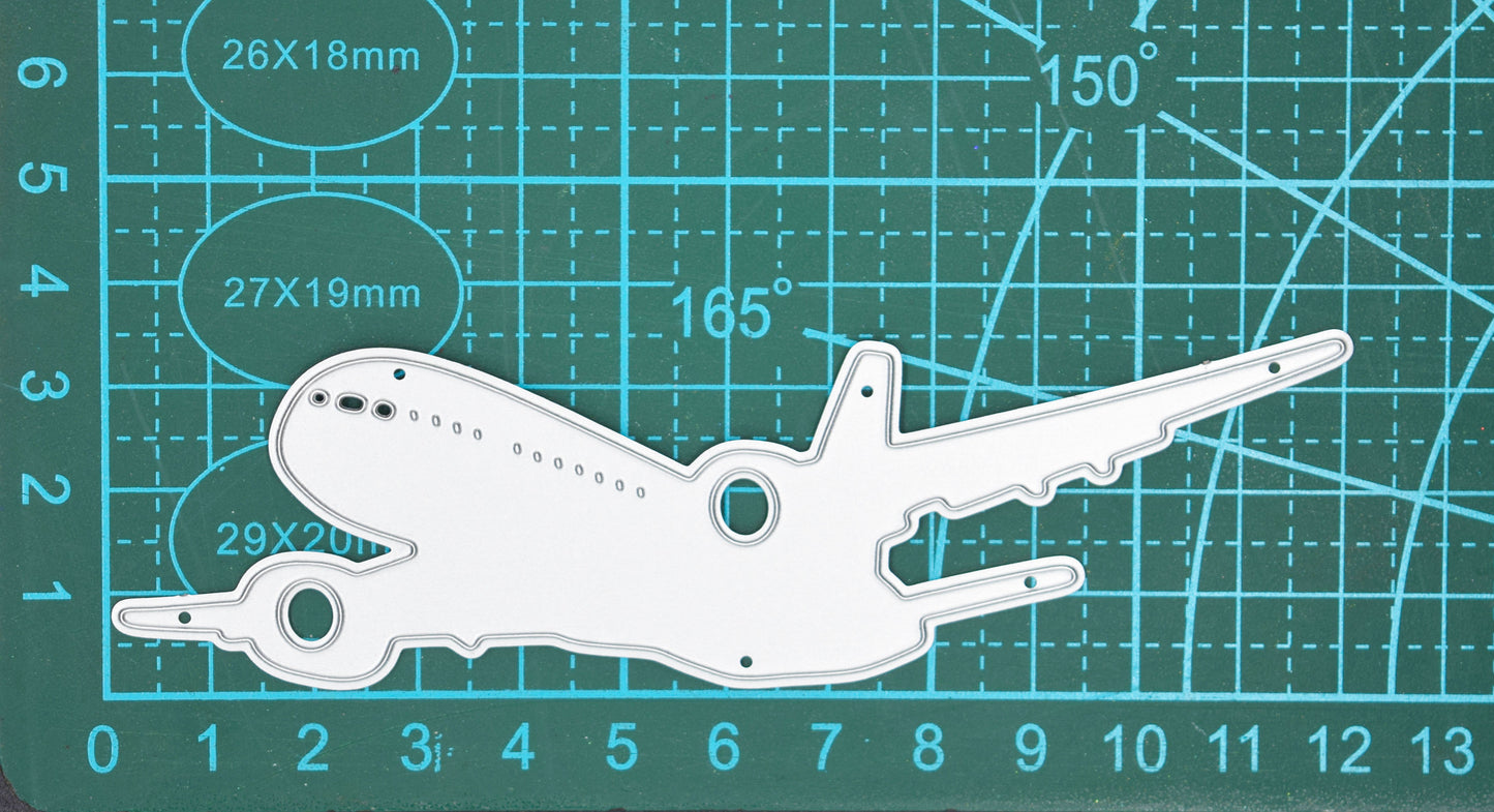 Jet aeroplane metal cutting die on cutting mat showing large passenger airplane silhouette for travel themed crafts and card making projects
