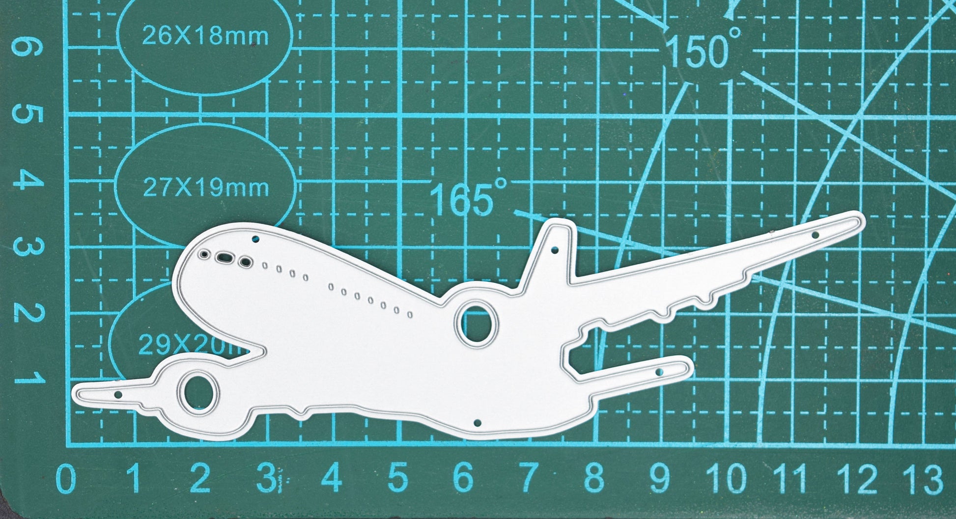 Jet aeroplane metal cutting die on cutting mat showing large passenger airplane silhouette for travel themed crafts and card making projects