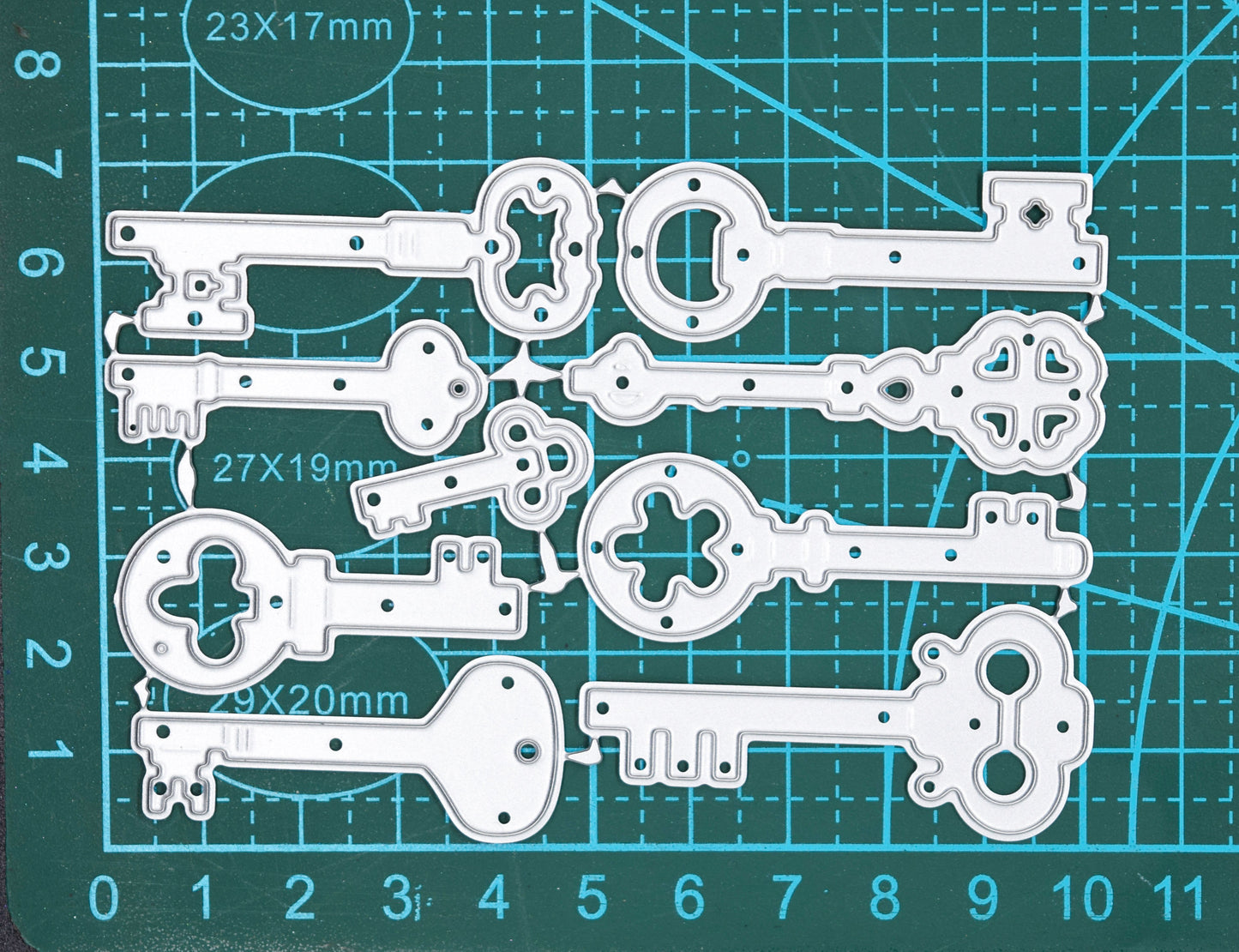 Vintage key metal cutting dies on cutting mat showing approximate sizes and assorted key designs