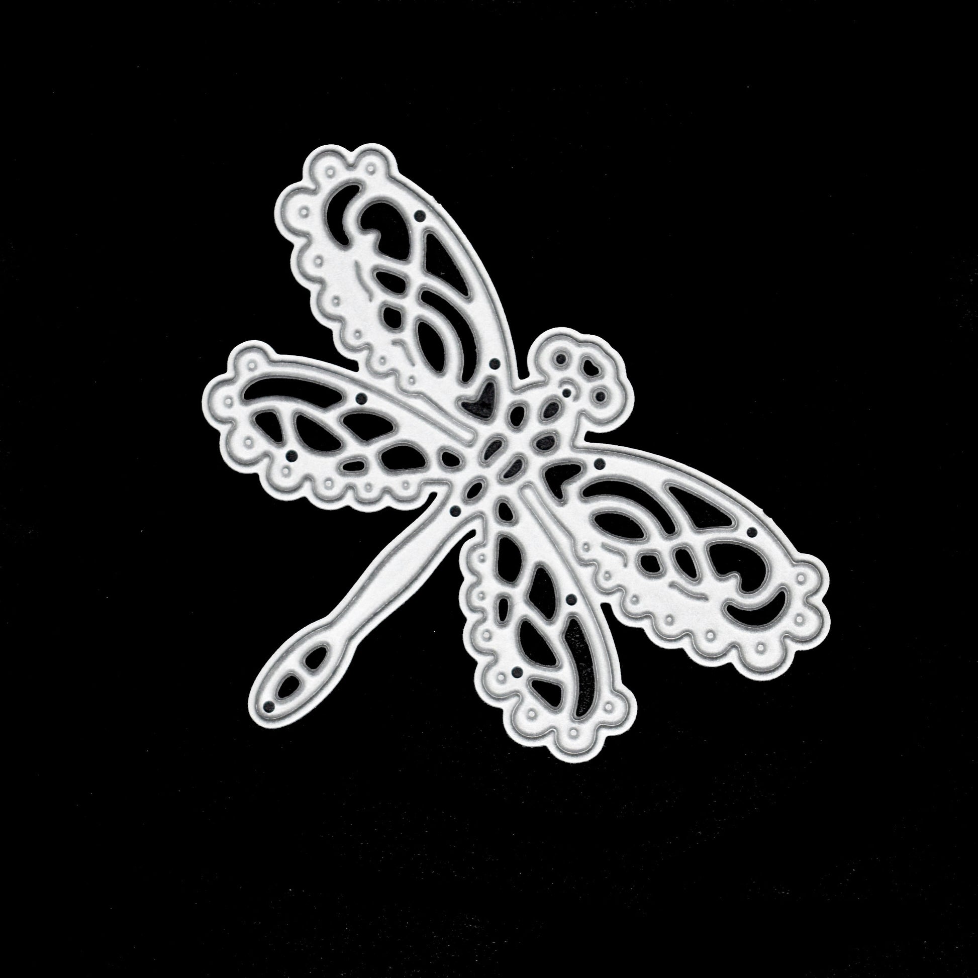 Decorative lace dragonfly metal cutting die photographed on black background for card making and craft projects