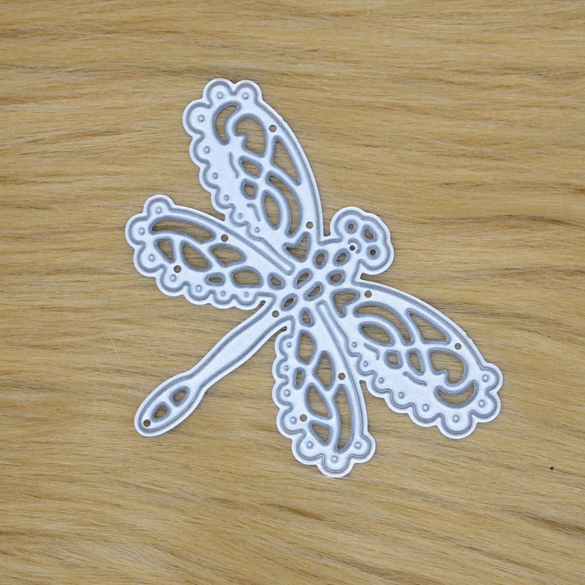 Lace dragonfly metal cutting die on faux fur background for handmade card making and decorative papercraft projects