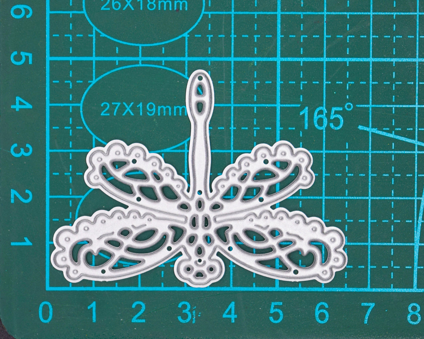Lace dragonfly metal cutting die on measuring craft mat showing approximate size for card making and papercraft use