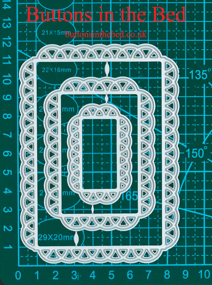 Three decorative lace edge rectangle nesting metal cutting dies shown against a centimetre measurement mat for scale.
