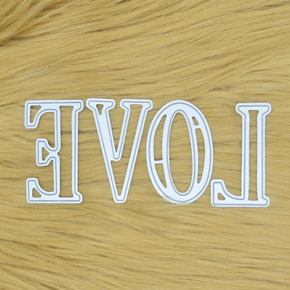 Large uppercase alphabet metal cutting dies arranged to spell LOVE on a faux fur background