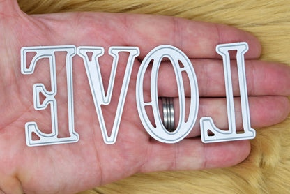 Large uppercase alphabet metal cutting dies shown in hand to demonstrate the 5 cm letter size