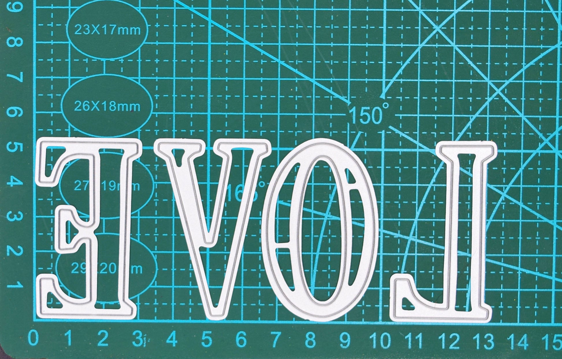 Large uppercase alphabet metal cutting dies shown on a cutting mat for size reference