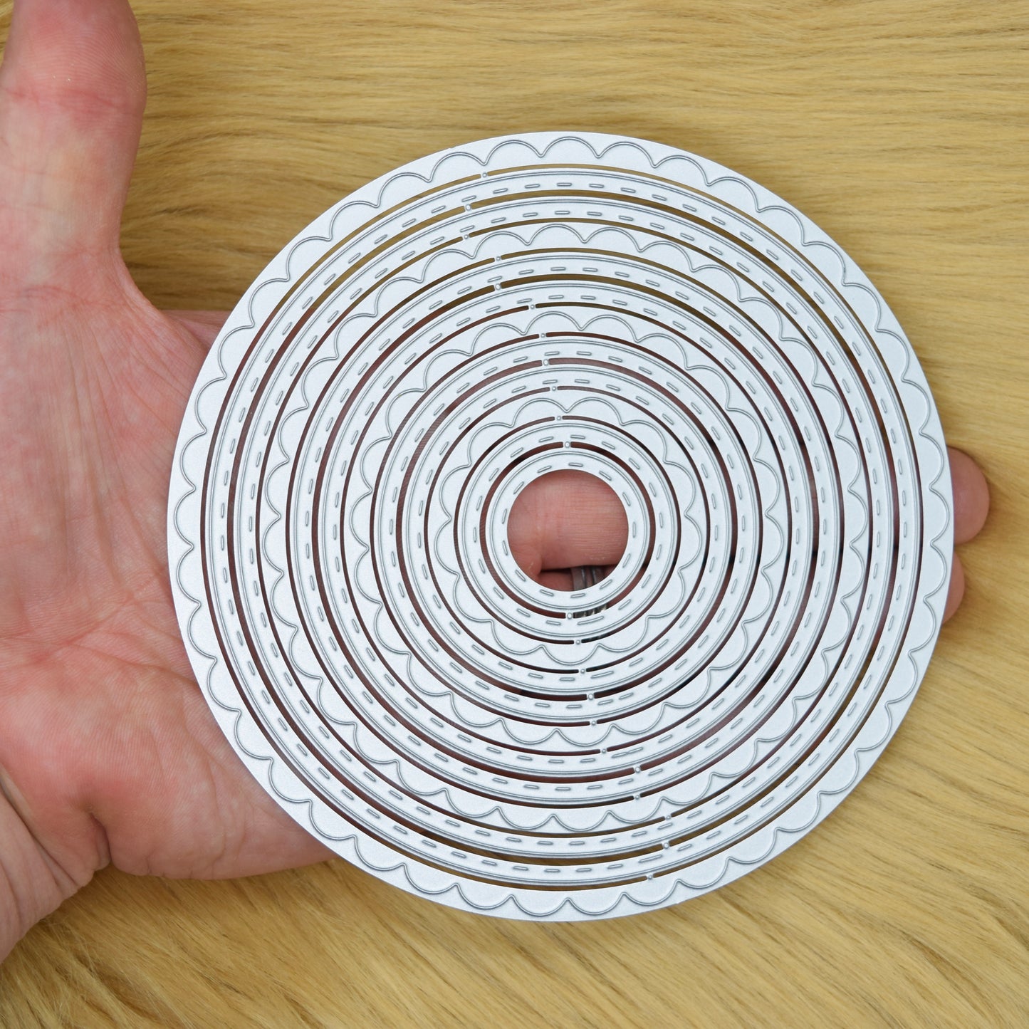 Large circle nesting dies shown in hand for size reference