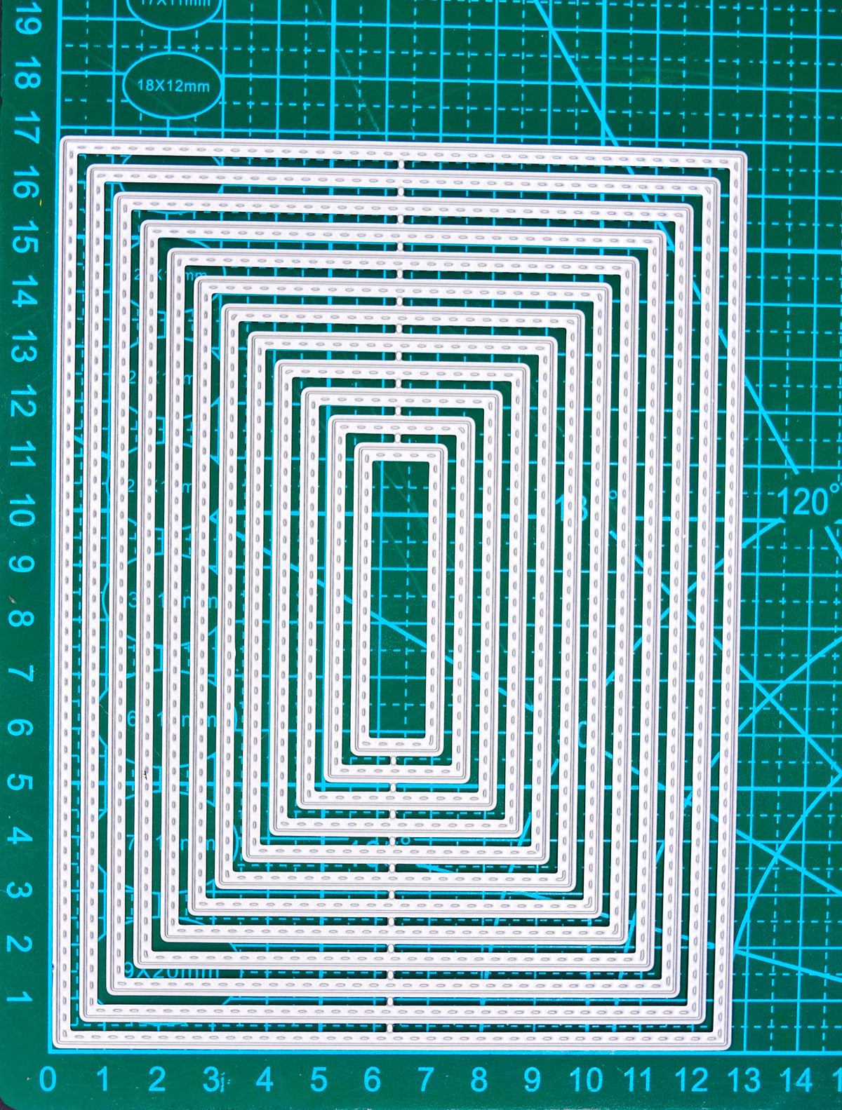 Stitched rectangle nesting cutting dies on a green centimetre cutting mat for size reference.