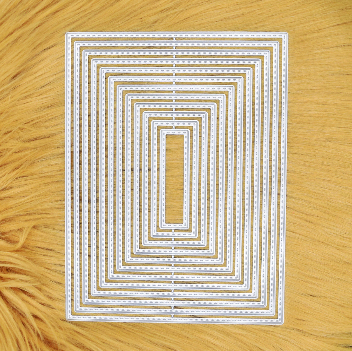 Set of 12 graduated stitched rectangle metal cutting dies displayed on a tan faux fur background.