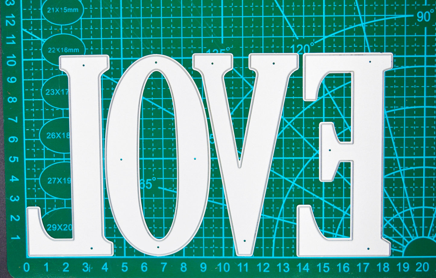 Very large uppercase alphabet metal cutting dies displayed on a centimetre cutting mat for clear size guidance.