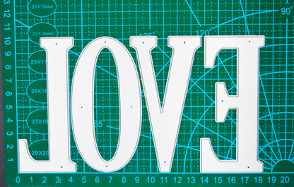 Very large uppercase alphabet metal cutting dies displayed on a centimetre cutting mat for clear size guidance.
