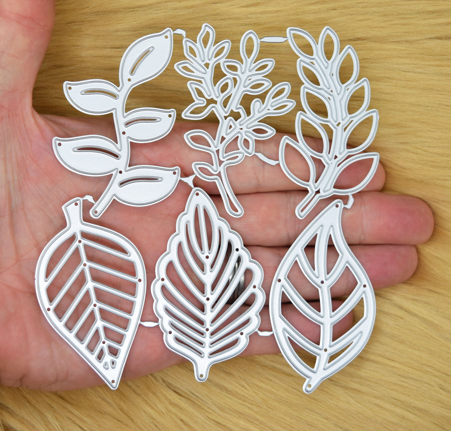 Leaf metal cutting dies set shown in hand for size reference