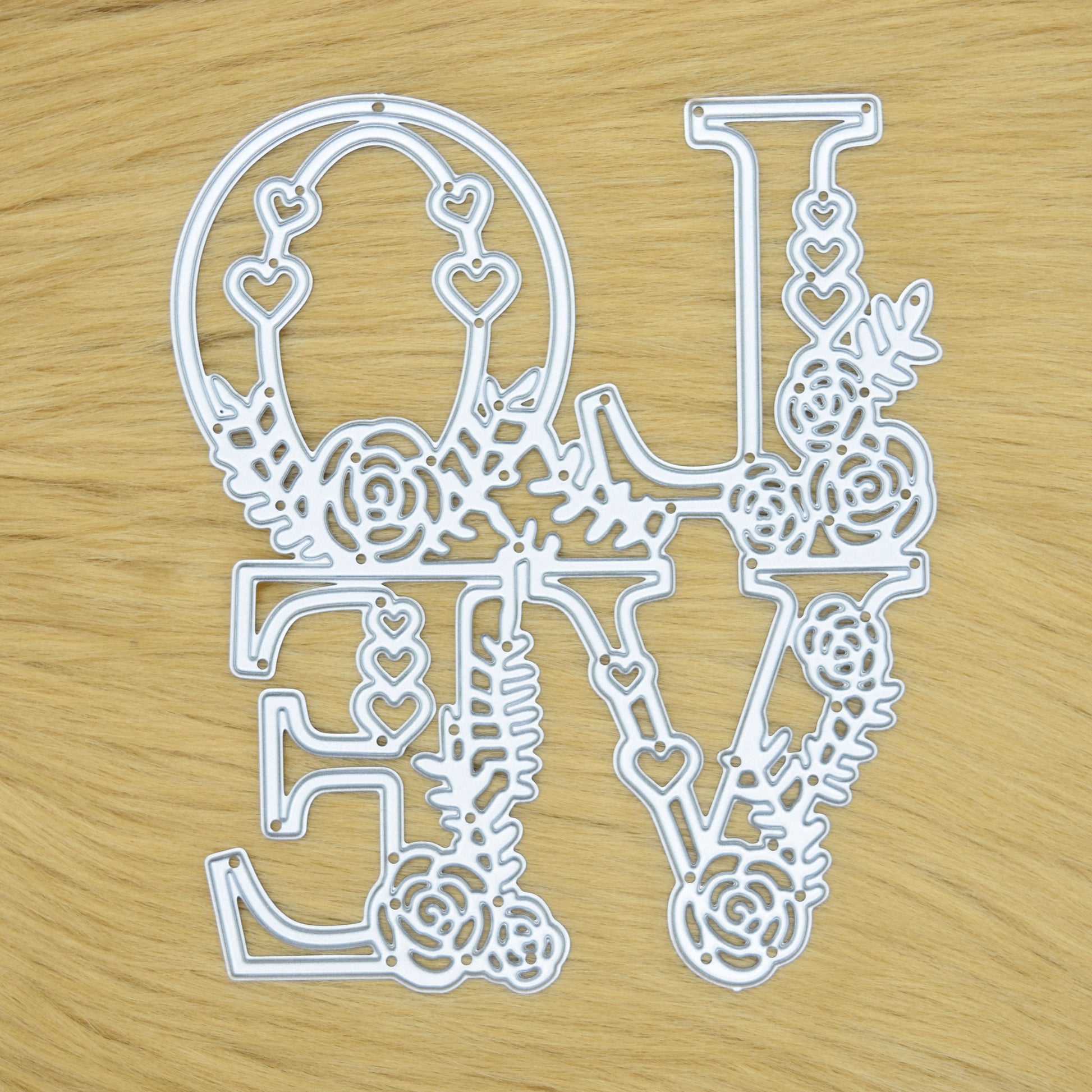 Floral LOVE metal cutting die on faux fur background showing detailed heart and flower design