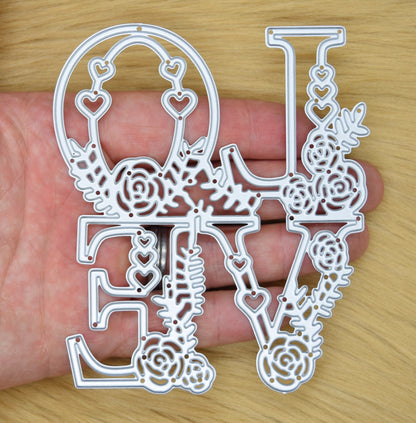 Floral LOVE metal cutting die held in hand showing size and detailed design for papercraft