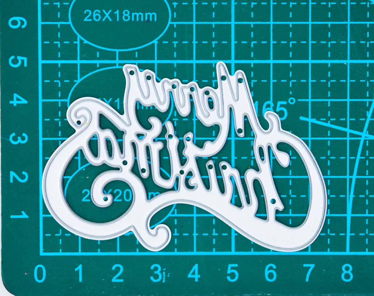 Merry Christmas script metal cutting die on a centimetre cutting mat, showing its width and height.