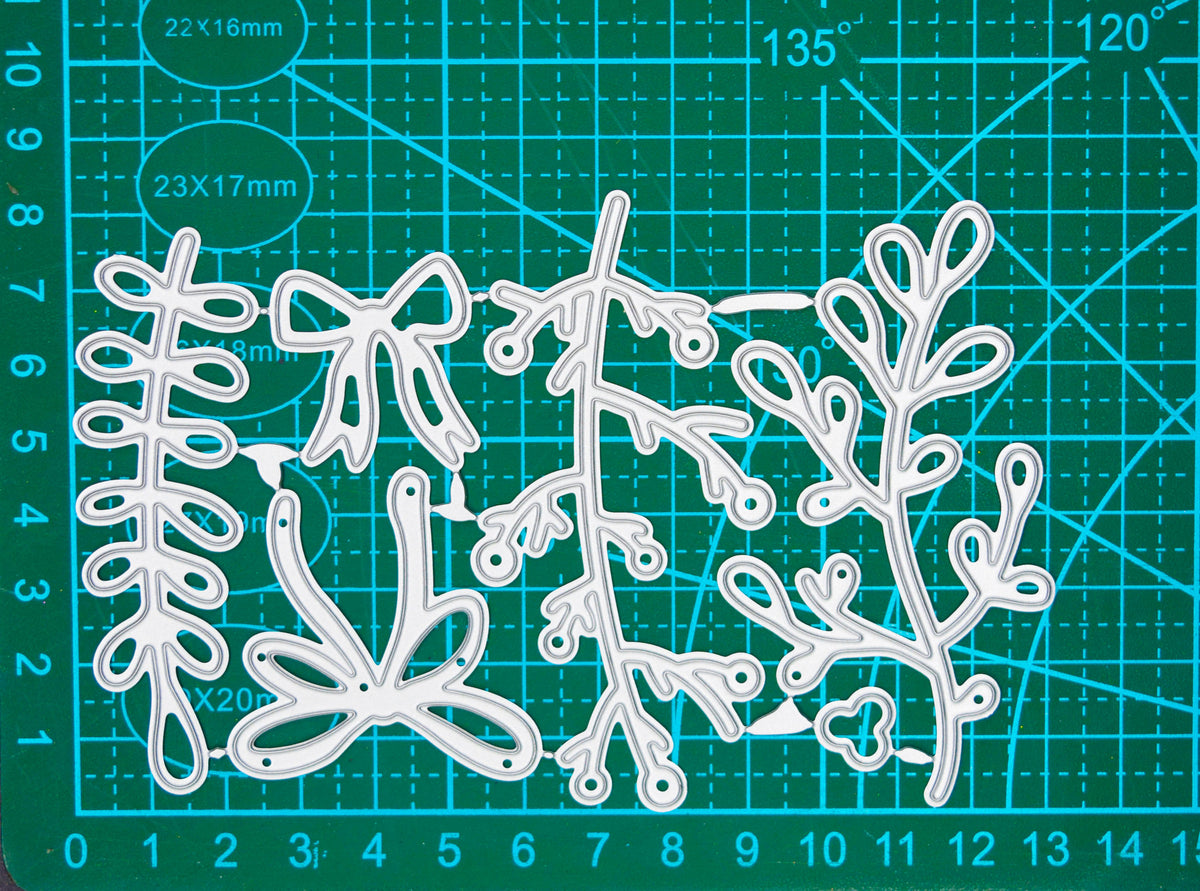 Mistletoe and bow metal cutting die set displayed on a centimetre cutting mat for size guidance.