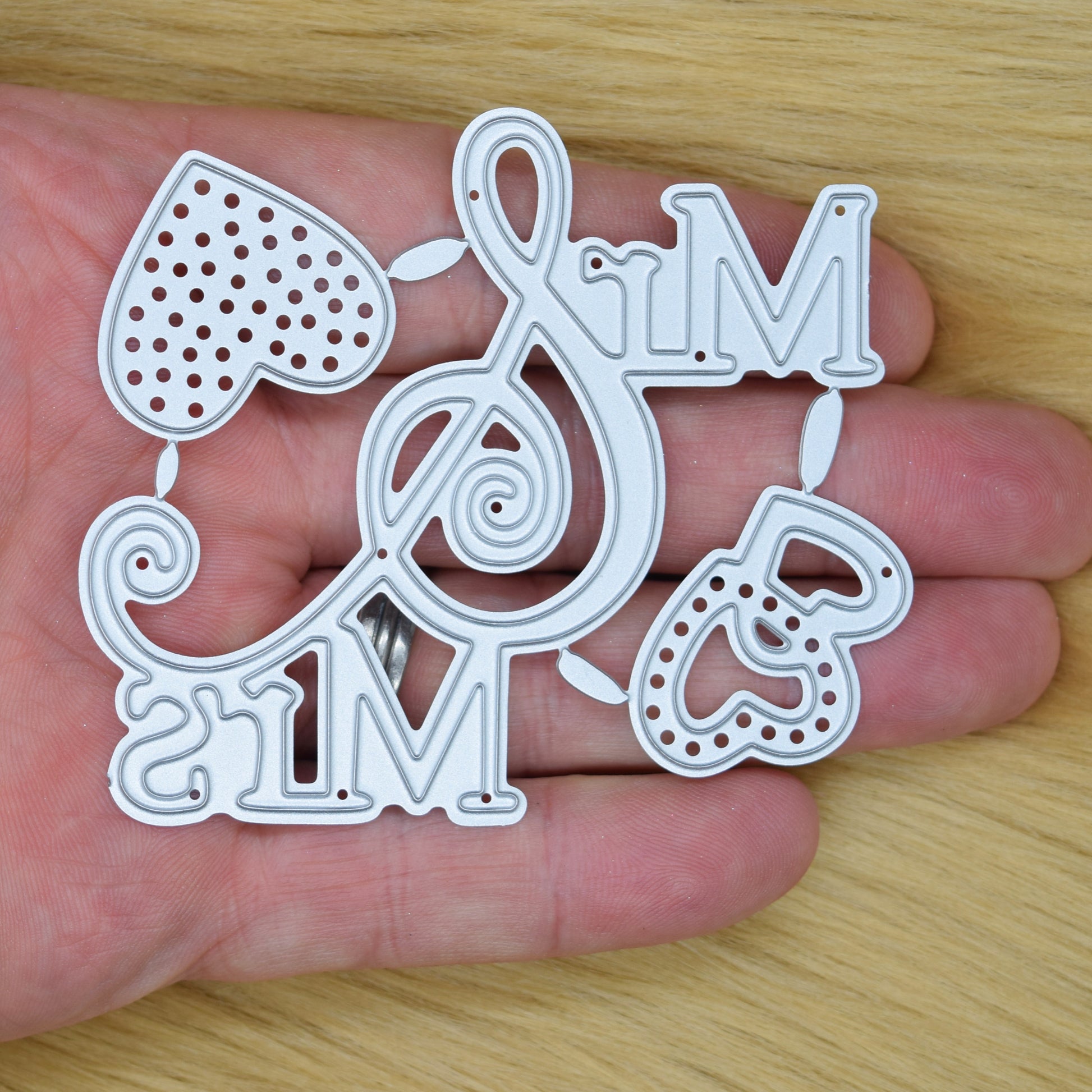 Mr and Mrs metal cutting die shown in hand for size reference featuring decorative hearts and swirled ampersand design