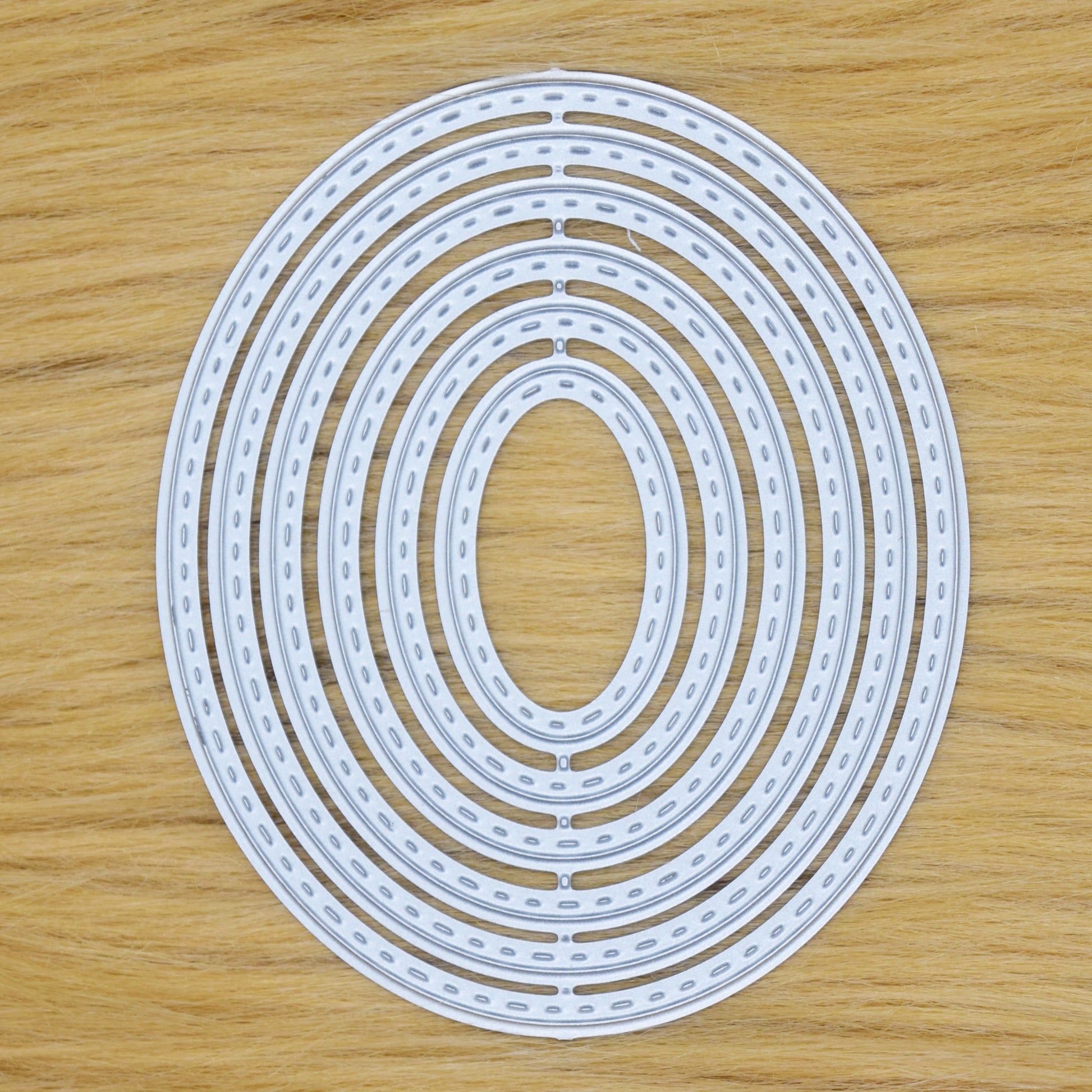 Nesting stitched oval dies set showing all 6 sizes for layered card making and papercraft