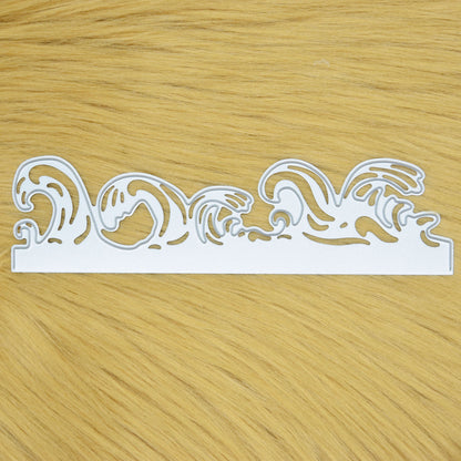 Ocean waves border metal cutting die held in hand to show the size of the decorative edging die