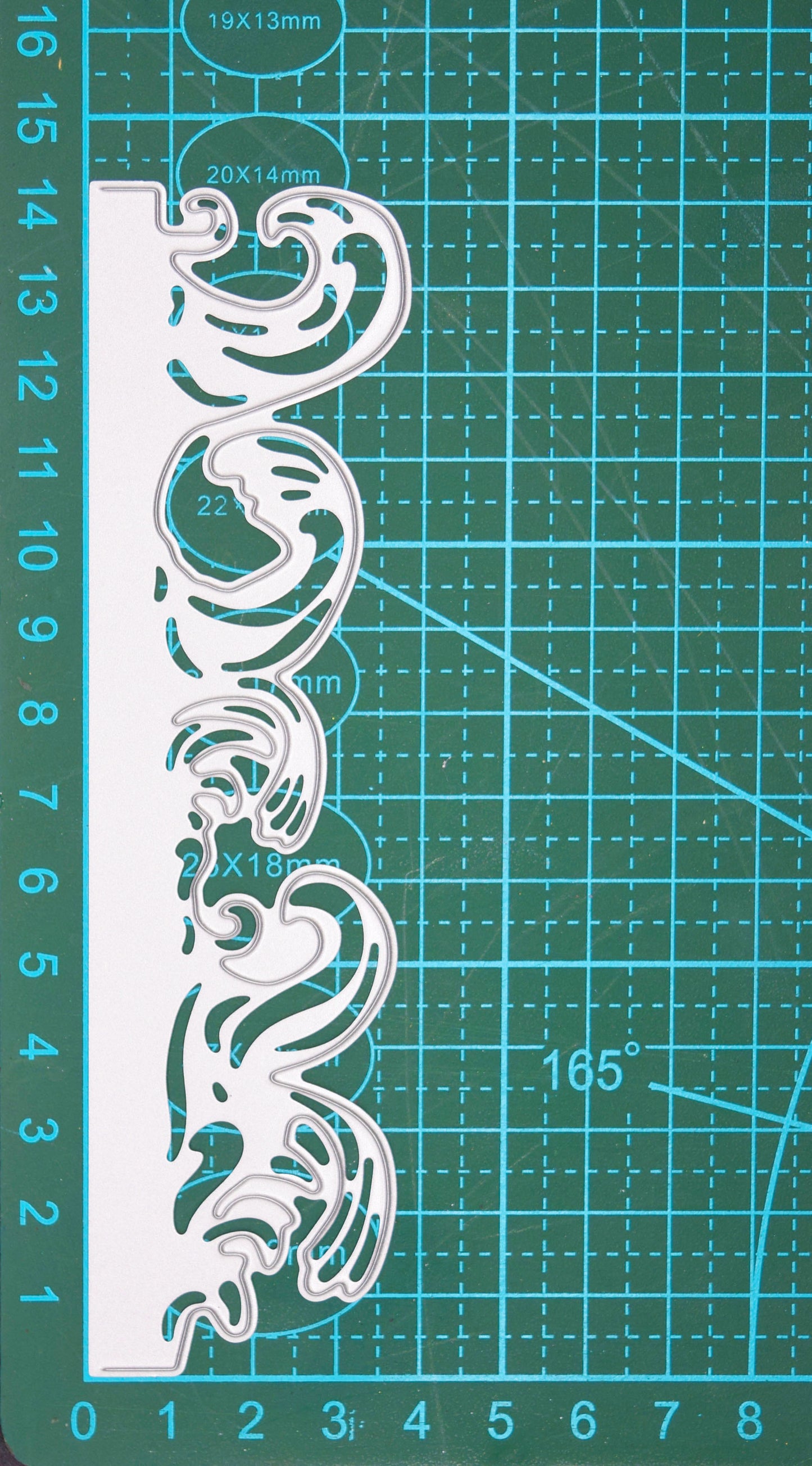 Ocean waves border metal cutting die shown on a centimetre cutting mat for size reference