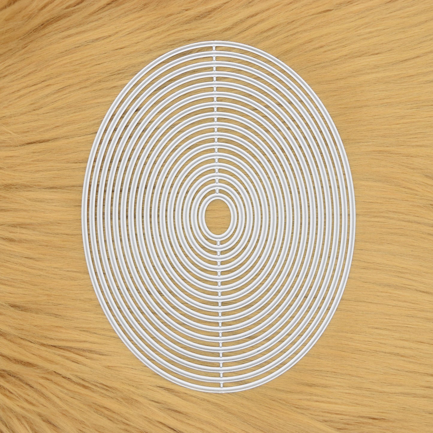 Oval nesting metal cutting dies set on faux fur background