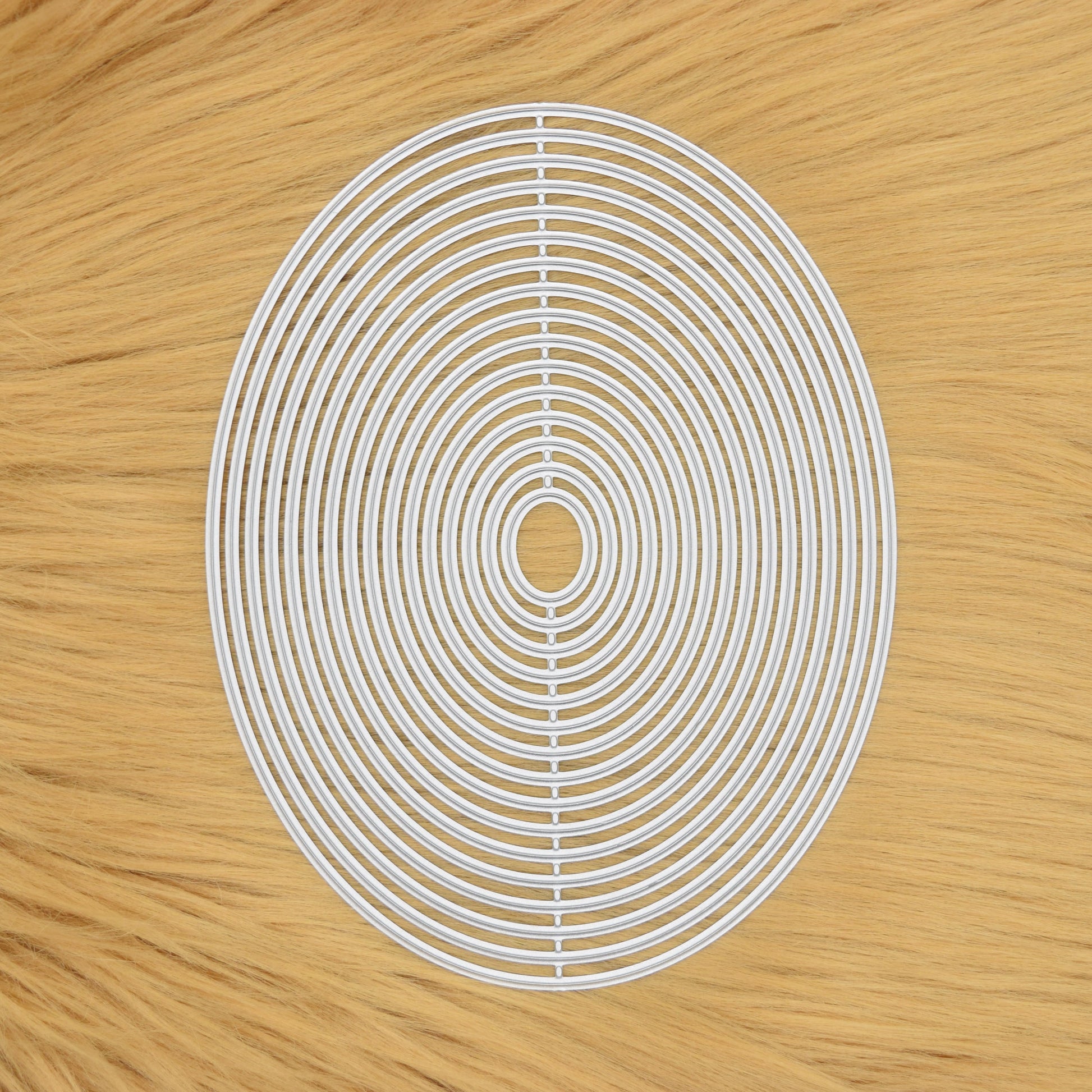 Oval nesting metal cutting dies set on faux fur background