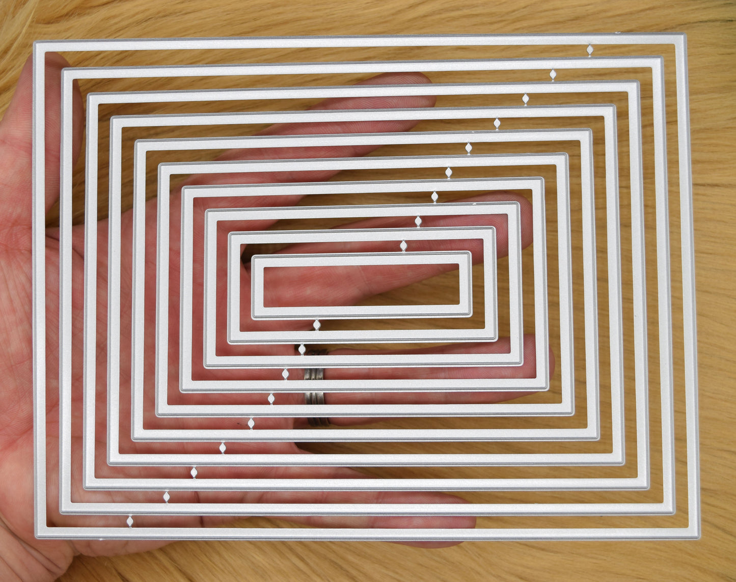 Plain rectangle nesting dies shown in hand for size reference and A6 card layering
