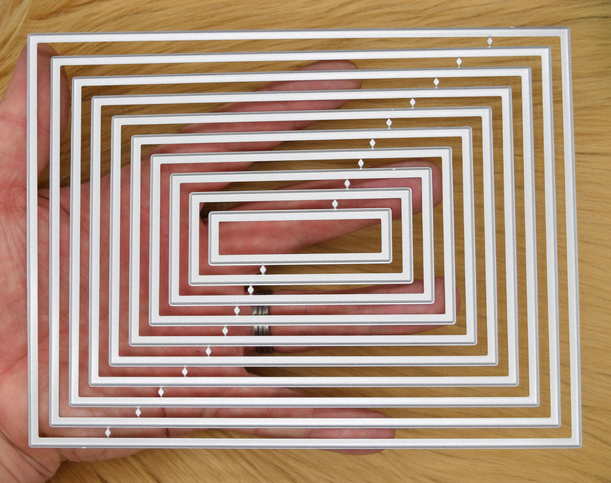 Plain rectangle nesting dies shown in hand for size reference and A6 card layering